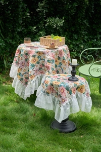Floral table cloth with pink jacquard patterns and white lace edges in a garden setting