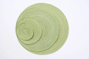 Detail of round woven placemats in green and white spiral pattern for table decor