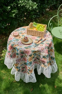 Close-up of floral fabric tablecloth with white double-layer lace ruffled edges