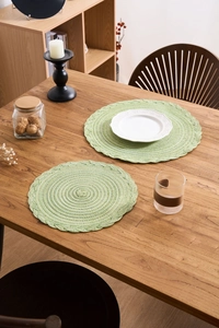 Detail of light green braided placemats with spiral texture on a wooden table