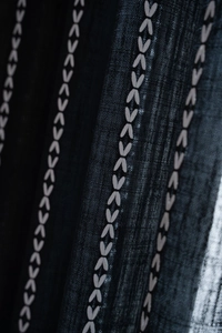 Macro shot of black mesh fabric curtain with elegant heart embroidery and delicate texture
