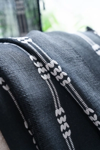 Détail du rideau occultant noir avec broderie blanche ajourée et texture tissée