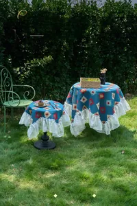 Detail of bohemian blue geometric tablecloth featuring elegant white lace ruffled edges
