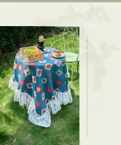 Detailed texture of blue geometric jacquard fabric with white lace edge on round tablecloth