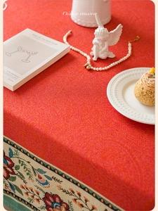Close-up of red tablecloth with jacquard floral patterns and traditional embroidered border