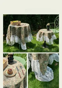 Detailed shot of green oil painting floral tablecloth with white lace ruffle edge