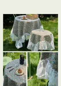 Detailed close-up of floral jacquard tablecloth with elegant white lace ruffle edges
