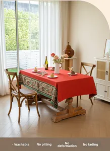 Detailed embroidery on a red vintage tablecloth featuring floral lace and cotton linen fabric