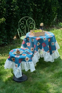 Detail of blue bohemian geometric tablecloth with white lace edges in outdoor setting
