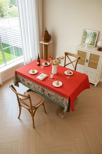 Detail of red rectangular tablecloth featuring vintage floral embroidery and jacquard edges