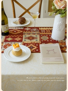 Detail view of Bohemian jacquard table runner with red diamond patterns and fringe
