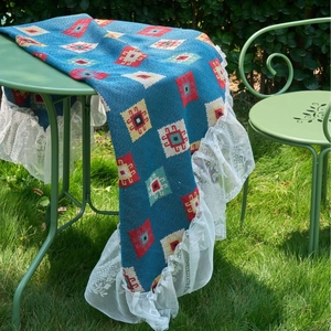 Bohemian blue geometric jacquard tablecloth with white lace edges on outdoor iron table