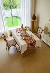 Detailed texture of bohemian red geometric jacquard tablecloth with fringe on a wooden table