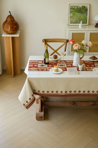 Detail of bohemian red geometric jacquard tablecloth with textured tassels and patterns