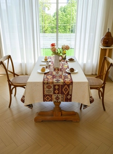Detail of red geometric bohemian tablecloth with woven jacquard pattern and fringes