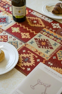 Macro detail of Bohemian red woven table runner with geometric jacquard patterns