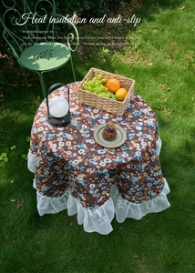 Detail of red vintage floral round tablecloth with elegant white double-layered lace edges