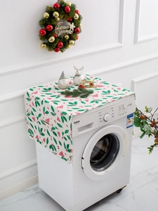 Close-up of Christmas themed washing machine dust cover with holly print and pom pom trim