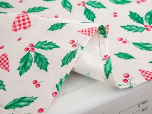 Detail of Christmas refrigerator cover with red berries, holly leaves and heart pattern