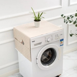 Close-up of beige polka dot washing machine cover with side storage pockets and tassels