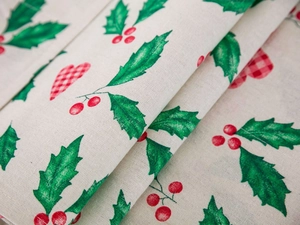 Detailed macro view of linen fabric with festive holly berries and checkered heart print