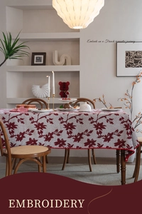 Dettaglio del ricamo floreale rosso vintage francese sul bordo di un'elegante tovaglia