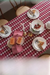 Detailed view of red and white checkered tablecloth in a festive home dining setting