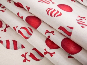 Detailaufnahme von Leinenstoff mit roten Weihnachtsmustern und gewebter Textur