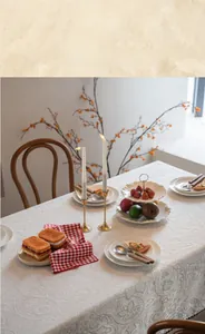 Detailed view of elegant white lace tablecloth with decorative gold candle holders