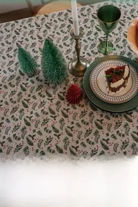 Christmas tablecloth featuring festive green pine needles and red berries on beige fabric