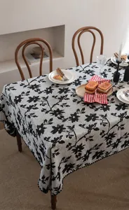 Dettaglio della tovaglia jacquard con ricami floreali in bianco e nero e motivi di rami