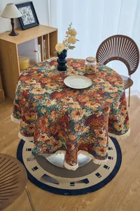 Detail of vintage oil painting style jacquard round tablecloth with cream fringe trim
