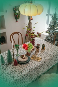 Detail of Christmas holly leaf print tablecloth with elegant dark green fringe tassels