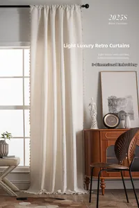 Detail of cream vintage curtain with 3D embossed embroidery and hanging tassel trim