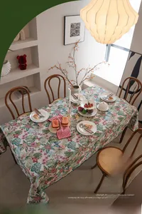 Detail of bohemian jacquard tablecloth with monstera leaf patterns on a wooden table