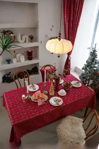 Detail der roten Weihnachts-Tischdecke mit Baummuster und roten Pompon-Verzierungen