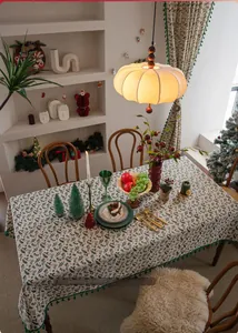 Close-up of Christmas holly leaf print tablecloth with elegant green tassel edge detail
