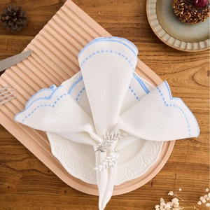 Silver leaf napkin ring on white embroidered cloth over a rustic wooden table setup
