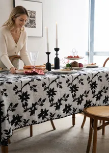 Dettaglio di tovaglia jacquard con motivi floreali neri ed elegante effetto drappeggio