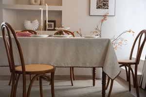 Close-up of cream jacquard tablecloth with vintage paisley patterns and coffee brown edge