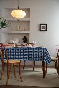 Close-up of blue and white checkered tablecloth with delicate lace edges on a wooden table