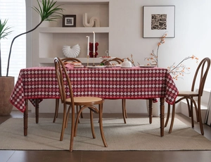 Close-up of a red diamond pattern jacquard tablecloth on a wooden dining table