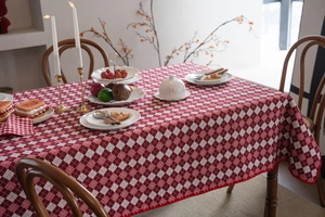 Close-up of red and white checkered tablecloth featuring scalloped wave edges on wood table