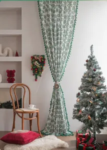Detail of Christmas curtain with green leaf patterns and a wooden elk tieback buckle