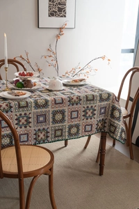 Dettaglio tovaglia jacquard retrò con patchwork geometrico e bordi a conchiglia verde scuro