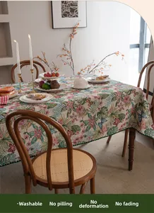Detailed close-up of bohemian jacquard tablecloth with floral patterns and green pom-poms