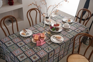 Detail of bohemian geometric jacquard tablecloth with fringe on a wooden dining table