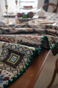 Dettaglio ravvicinato della tovaglia jacquard bohémien con motivi floreali tessuti