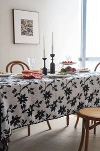 Tovaglia jacquard artistica con fiori neri e bianchi su tavolo in legno elegante