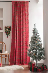 Detailed view of red Christmas curtain with green trees and festive pom-pom trim